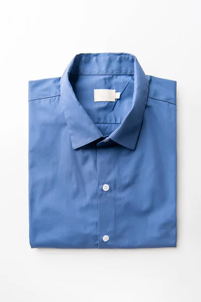 新しいブルーのメンズシャツ白い背景に折り畳まれた — ストック写真