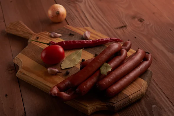 Sausage and spices on a wooden tablet or laptop — Stock Photo, Image
