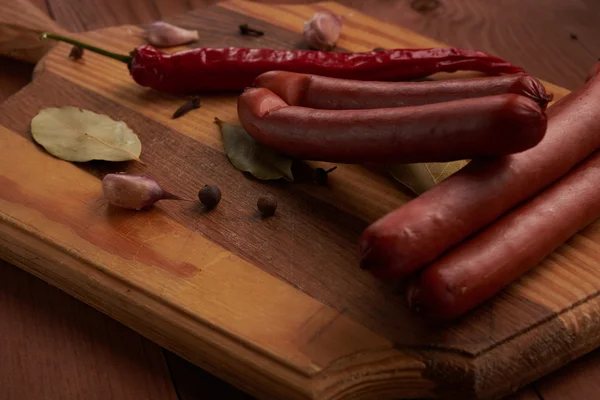 Колбаса и специи на деревянной табличке или ноутбуке — стоковое фото