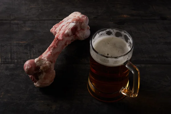 Grande osso e cerveja em uma mesa — Fotografia de Stock