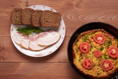 sahanda yumurta ve domuz pastırması ahşap bir masa üzerinde