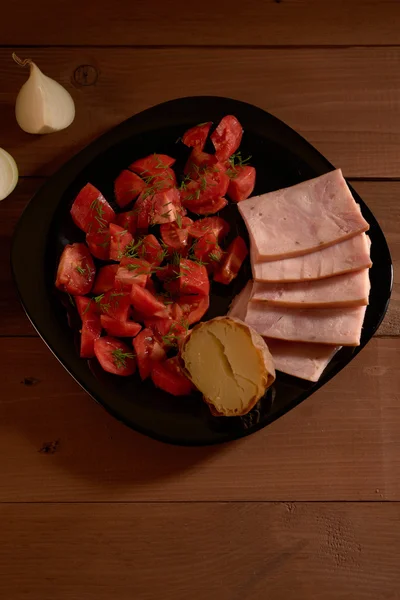 Batatas cozidas no forno e uma salada de tomates — Fotografia de Stock