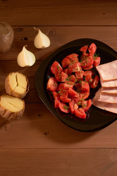 Pommes de terre au four et une salade de tomates — Photo