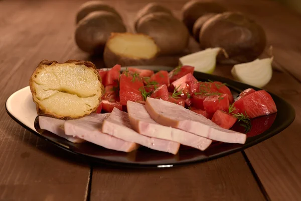 Pommes de terre au four et une salade de tomates — Photo