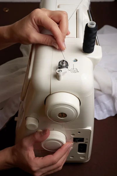 Kadın dikiş makinesi üzerinde iş parçacığı oluşturma — Stok fotoğraf