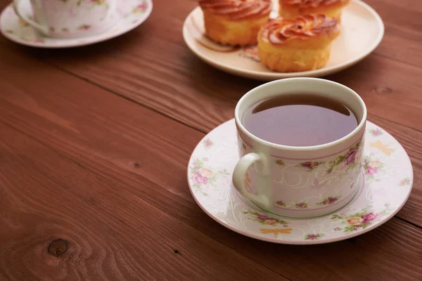Чай и сладости на деревянном столе — стоковое фото