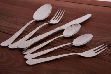 ahşap bir masa üzerinde çatal bıçak seti