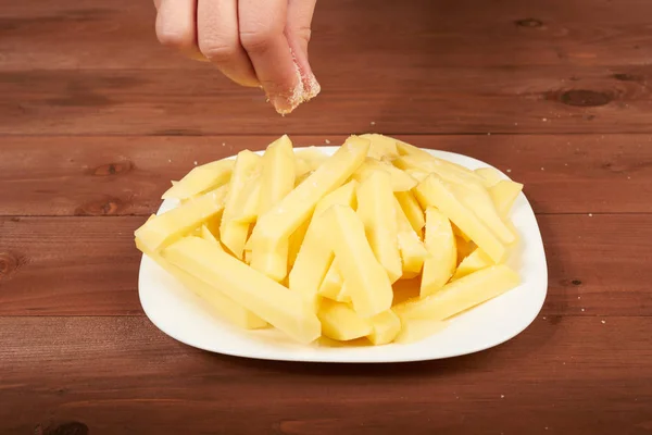 Rebanando patata cruda en el plato — Foto de Stock