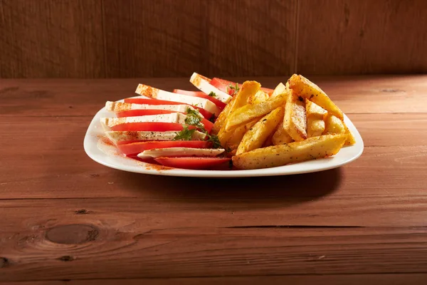 Salada com tomate e batatas fritas de queijo — Fotografia de Stock