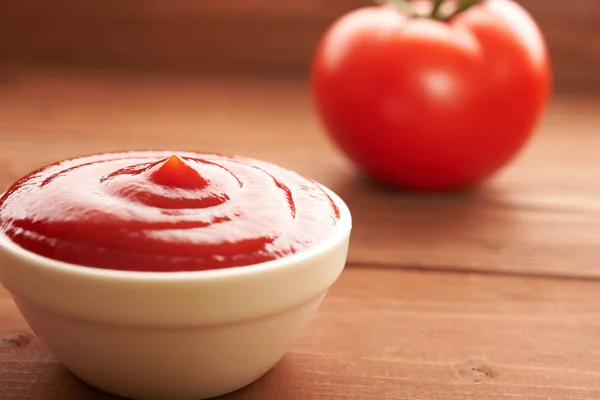 Ketchup i pomidorów na drewnianym stole — Zdjęcie stockowe