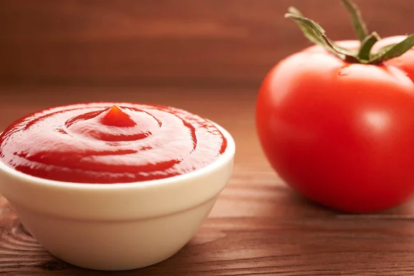 Ketchup i pomidorów na drewnianym stole — Zdjęcie stockowe