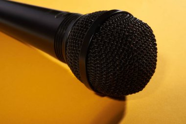 Sarı bir arka plan üzerinde siyah stüdyo mikrofon