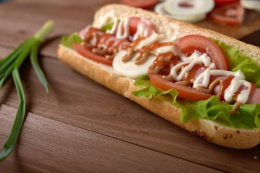 sandviç sosis ve ahşap bir masa üzerinde sebze ile