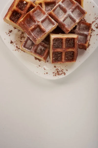 Belgian waffles with grated chocolate and icing on a white plate — Stock Photo, Image