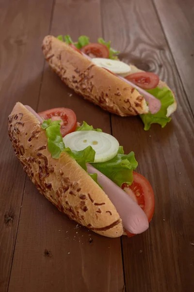 Sandwich met worst en groenten op een houten tafel — Stockfoto