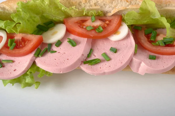 Sanduíche com linguiça e legumes isolados — Fotografia de Stock