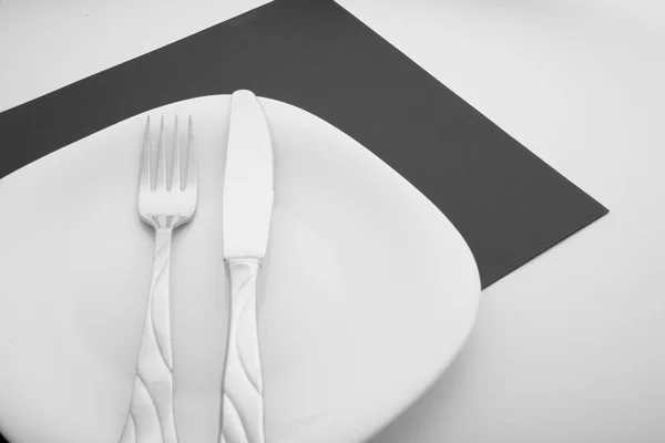 Cuchillo, tenedor y plato sobre fondo blanco —  Fotos de Stock