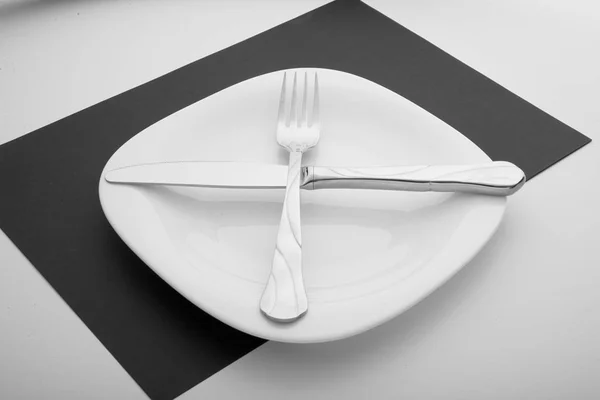 Knife, fork and plate on a white background — Stock Photo, Image