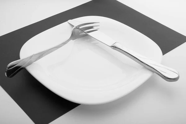 Knife, fork and plate on a white background — Stock Photo, Image