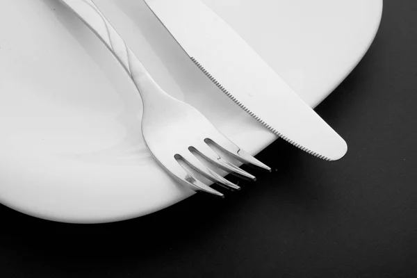 Cuchillo, tenedor y plato sobre fondo blanco —  Fotos de Stock