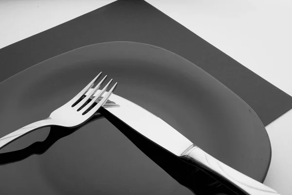Cuchillo, tenedor y plato sobre fondo blanco — Foto de Stock