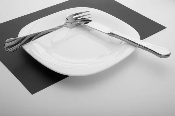 Knife, fork and plate on a white background — Stock Photo, Image