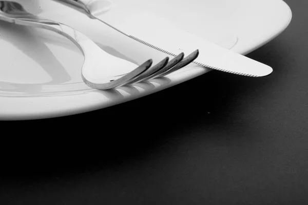 Knife, fork and plate on a white background Stock Picture