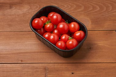 Tahta masadaki kiraz domatesleri.