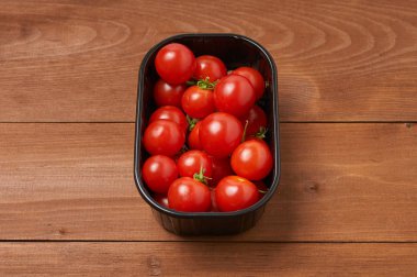 Tahta masadaki kiraz domatesleri.