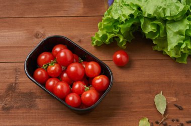 Tahta masadaki kiraz domatesleri.
