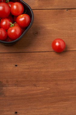 Tahta masadaki kiraz domatesleri.