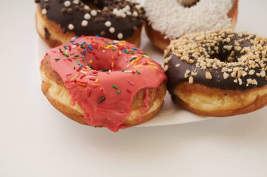 beyaz zemin üzerinde bir tabakta donut