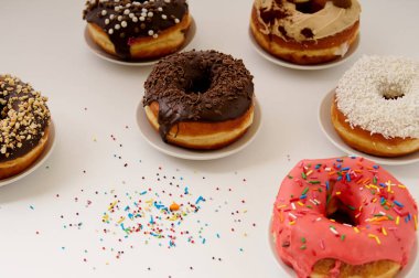 beyaz zemin üzerinde bir tabakta donut