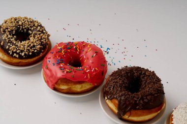 beyaz zemin üzerinde bir tabakta donut