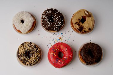 beyaz zemin üzerinde bir tabakta donut