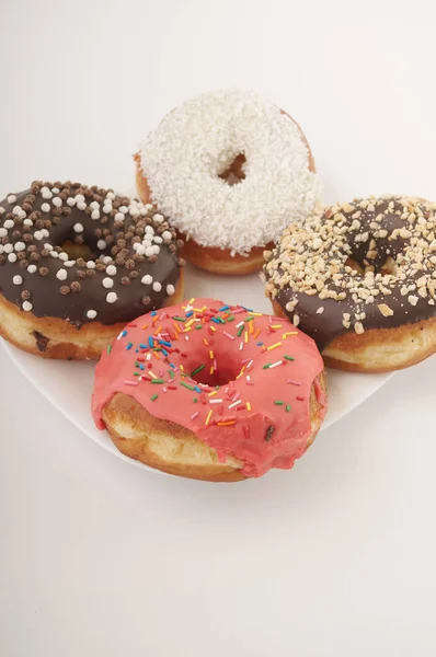 Rosquillas en un plato sobre un fondo blanco — Foto de Stock