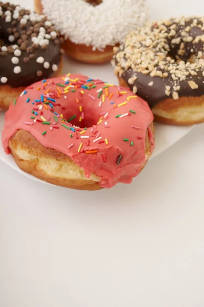 Donuts auf einem Teller auf weißem Hintergrund — Stockfoto