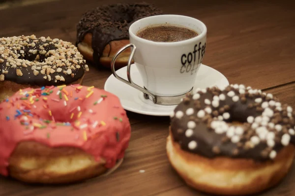 Donuts und Kaffee auf einem Holztisch — Stockfoto