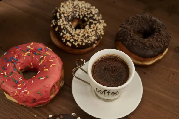 Donuts e café em uma mesa de madeira — Fotografia de Stock