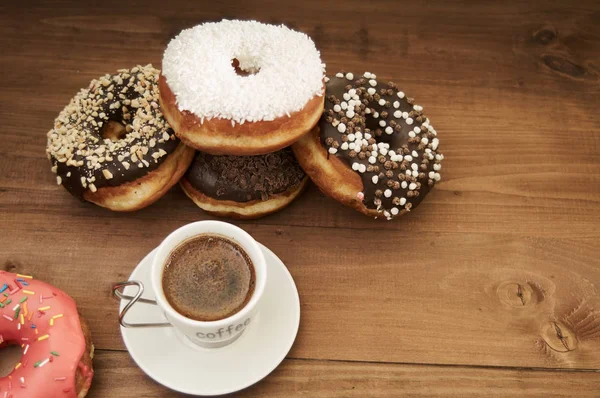 Donuts e café em uma mesa de madeira — Fotografia de Stock