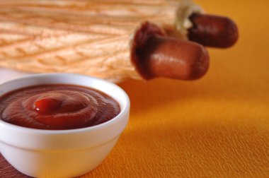 Sarı bir arka plan üzerinde iki sosisli sandviç