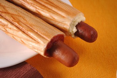 Sarı bir arka plan üzerinde iki sosisli sandviç