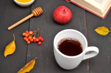 Sonbahar natürmort fincan çay, bal ve kitap masada