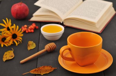 Sonbahar natürmort fincan çay, bal ve kitap masada