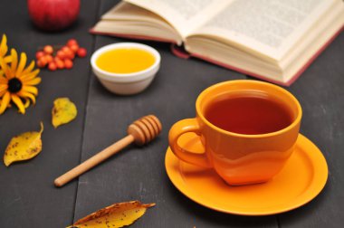Sonbahar natürmort fincan çay, bal ve kitap masada
