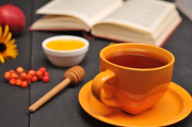 Sonbahar natürmort fincan çay, bal ve kitap masada
