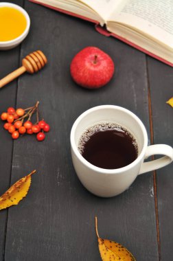 Sonbahar natürmort fincan çay, bal ve kitap masada