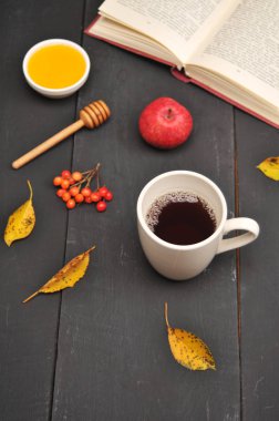 Sonbahar natürmort fincan çay, bal ve kitap masada