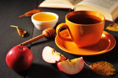 Sonbahar natürmort fincan çay, bal ve kitap masada