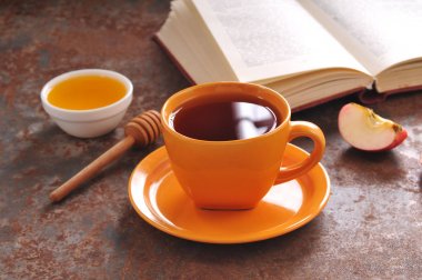 Sonbahar natürmort fincan çay, bal ve kitap masada